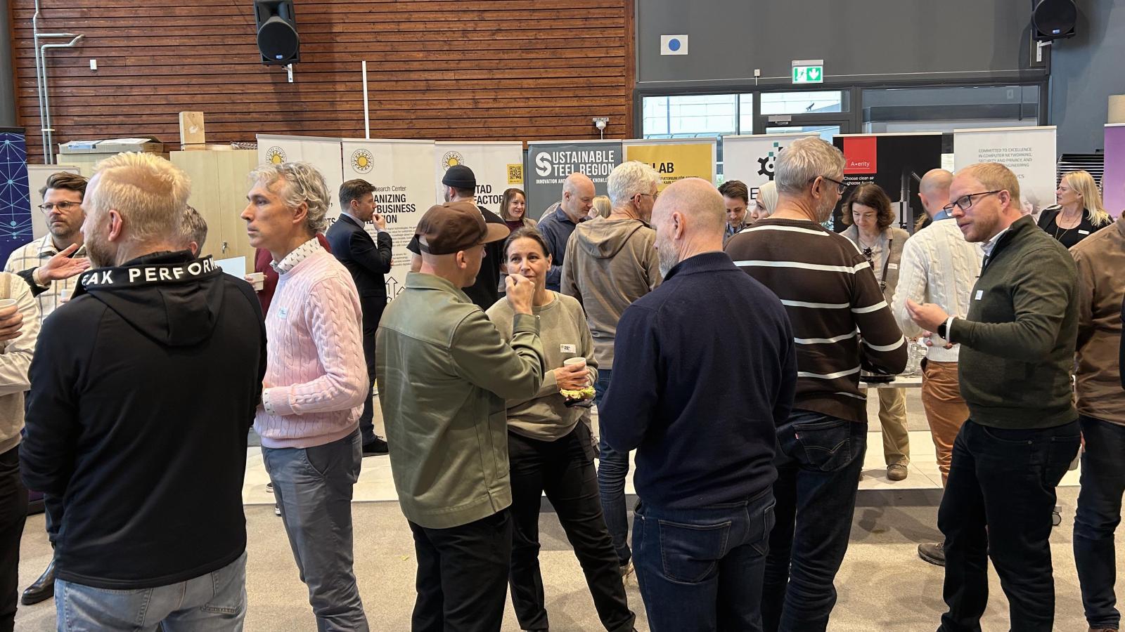 många människor som står och fikar och pratar med varandra