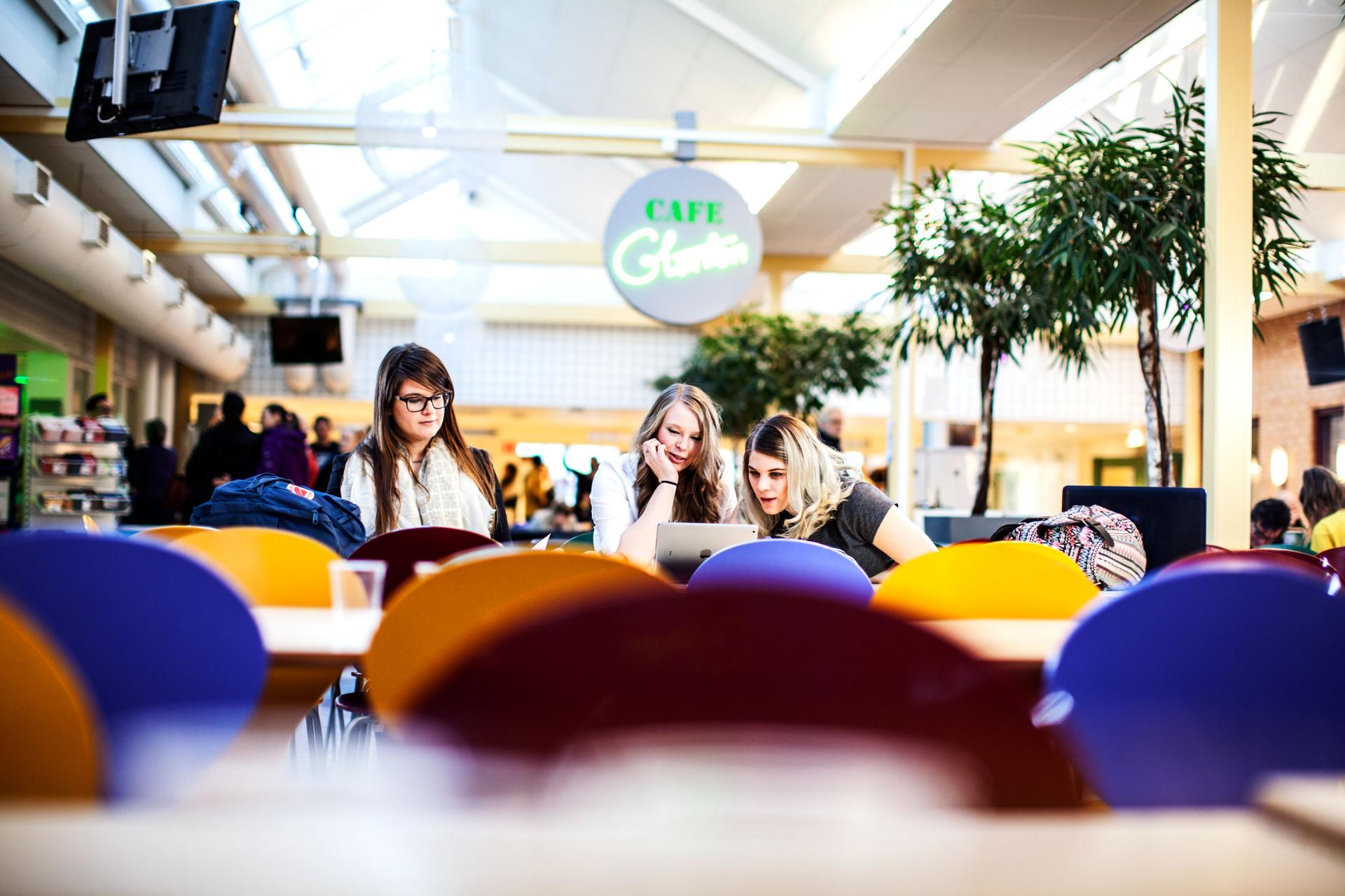 Studenter i café med färgglada stolar