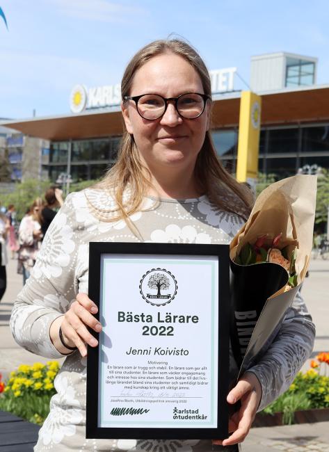 Jenni Koivisto håller upp sitt diplom